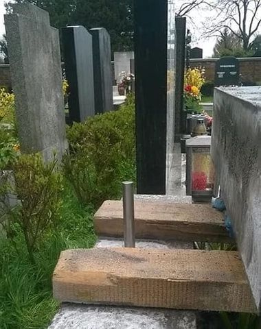 Reihe von Grabsteinen mit befestigten Holzbalken und Metallstangen